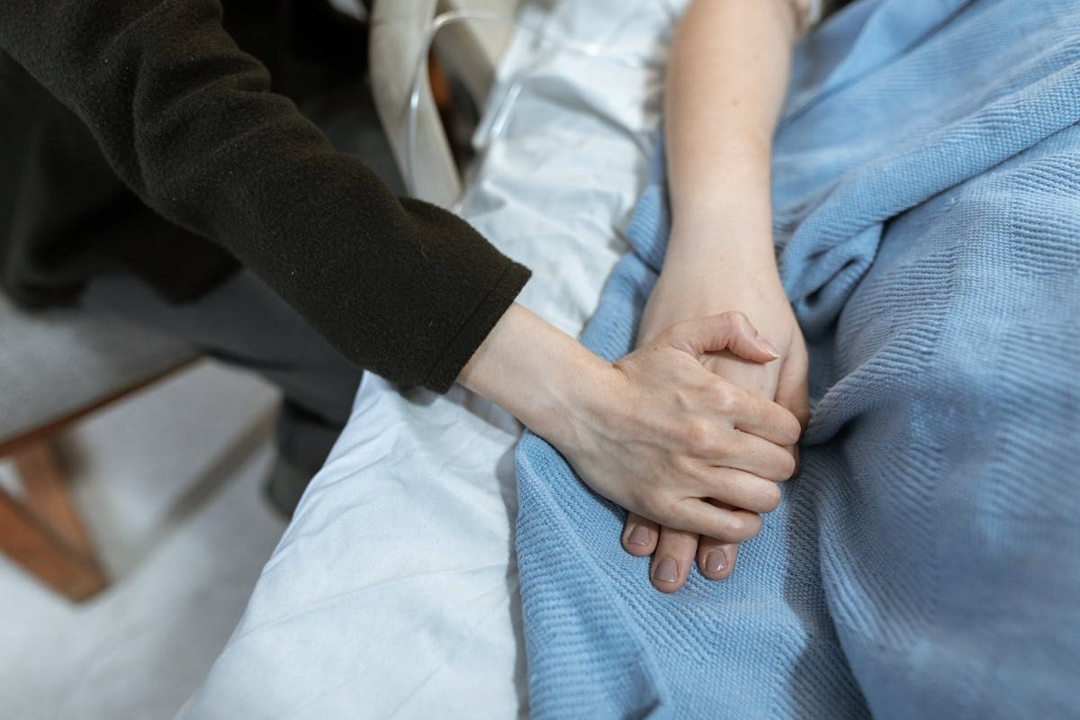 Comforting hand hold in a hospital setting, representing compassionate support during loss