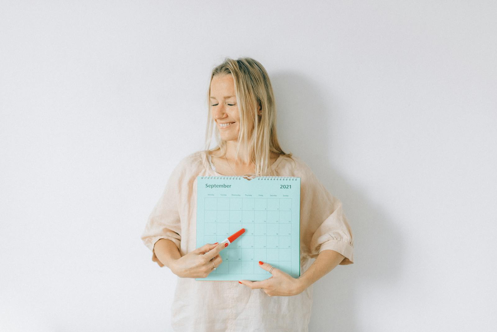 Woman pointing at a calendar date, representing pregnancy planning and scan scheduling